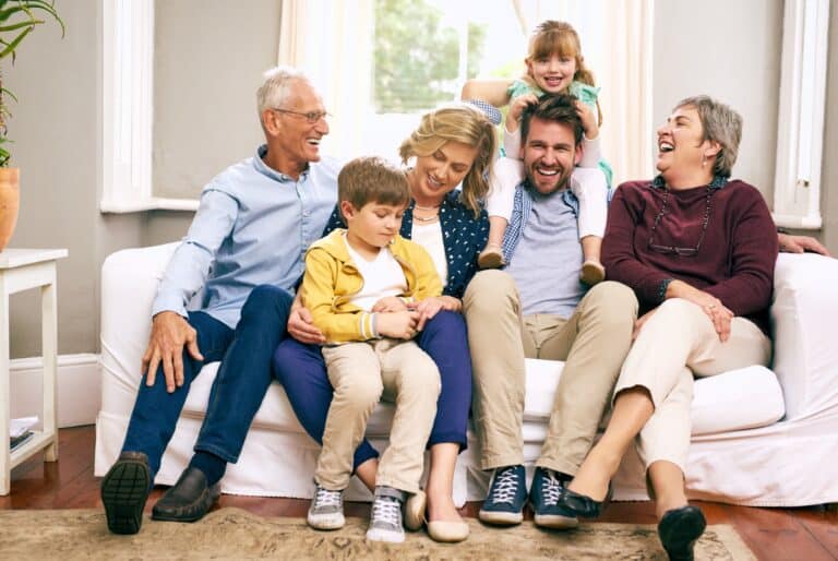 A multigenerational family sitting on the sofa at home.