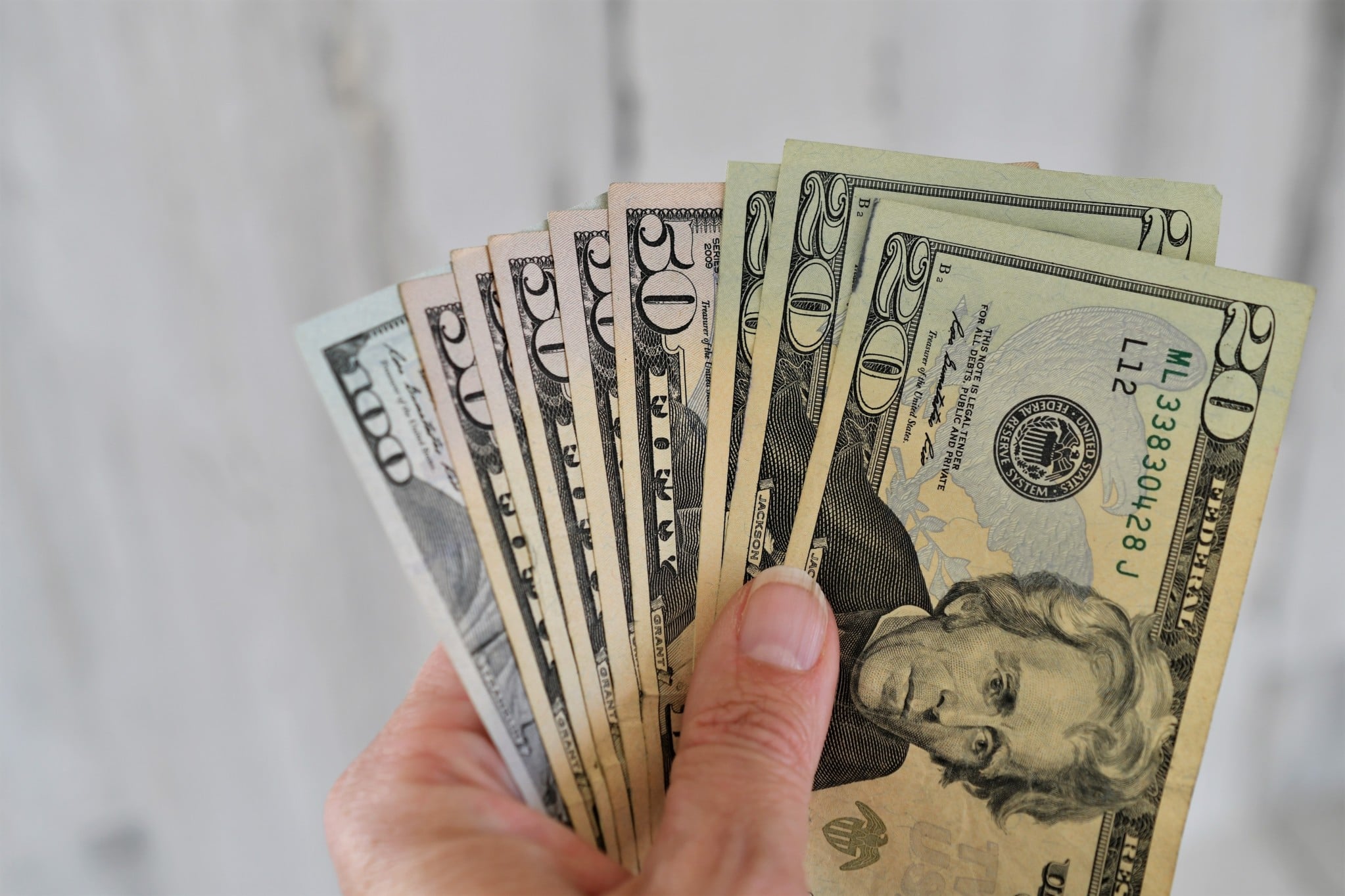 A hand holds a handful of money