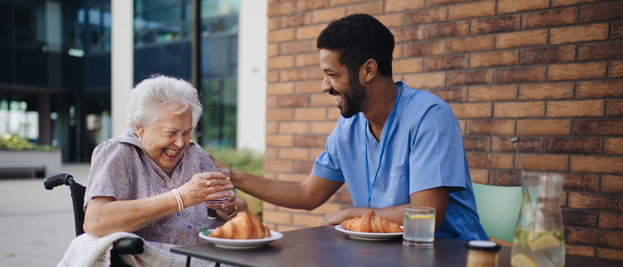 Caregiver having breakfast with his client at cafe.